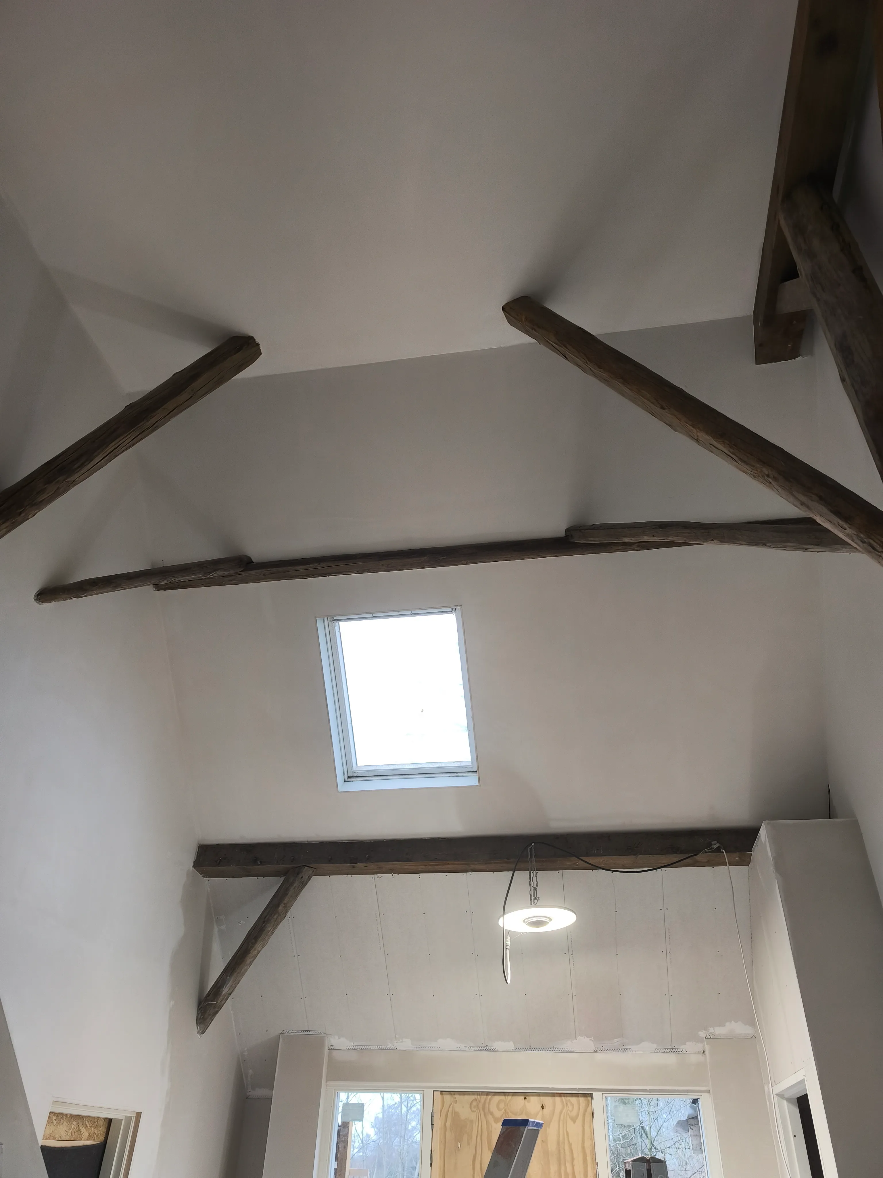 sausklaar zolderplafond met houten balken en dakraam