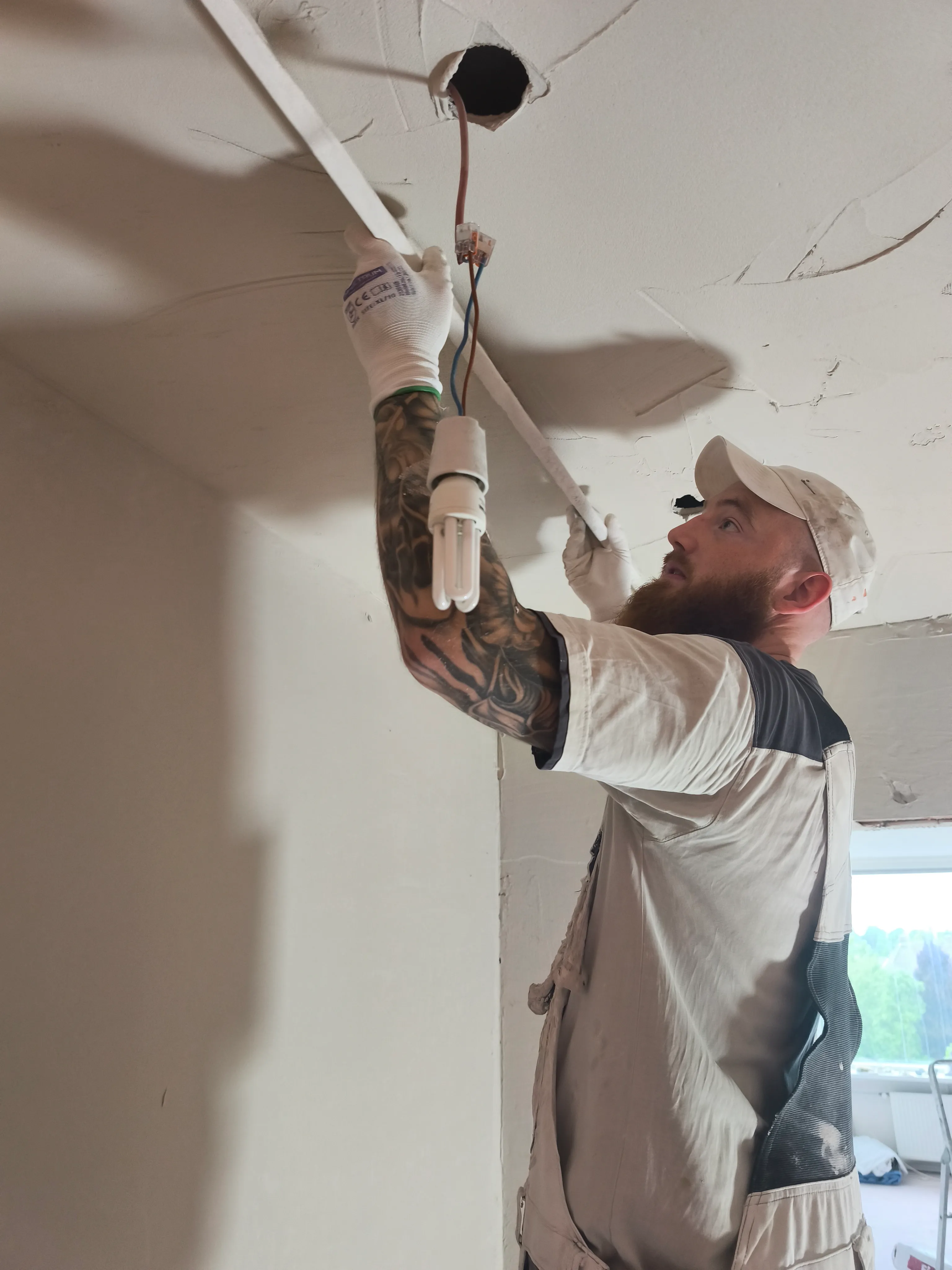 stukadoor werkt aan een lichtpunt in het plafond